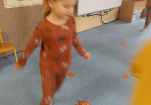 Dzieci biegają po dywanie dookoła dyni